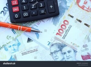 billetes argentinos y calculadora sobre mesa