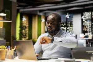 empleado mirando reloj en oficina moderna