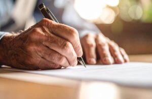 manos firmando documentos legales de pension