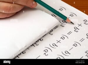 manos resolviendo ecuaciones algebraicas en papel