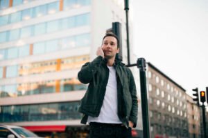 persona hablando por telefono en vecindario urbano