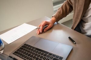 persona trabajando en computadora con documentos